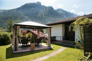 卡普伦Chalet Sabrina mit Außenpool im Sommer的庭院内带桌椅的凉亭