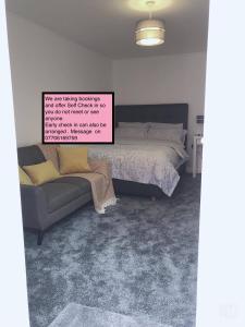 诺丁汉Flat 2 - Entire Modern Two Bedrooms home with en-suite & free parking close to QMC, City centre and Notts uni - Self check in的一间卧室配有一张床和一张沙发