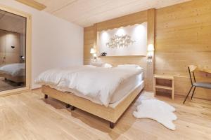 尚佩里Boutique Hotel Beau-Séjour & Spa Superior的卧室配有一张白色大床和镜子