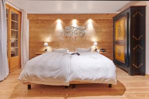 尚佩里Boutique Hotel Beau-Séjour & Spa Superior的卧室配有白色的床和木墙