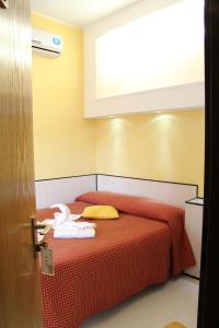 米兰卢伽诺酒店的一间卧室配有红色的床和毛巾