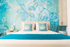 圣安德烈斯Sea Colors Hotel的一间卧室配有一张蓝色花卉壁纸的床