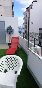 大加那利岛拉斯帕尔马斯阿卡拉瓦内拉斯青年旅舍的阳台的红色椅子和桌子