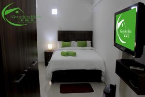 马普托Green Stay house的酒店客房设有一张床铺,墙上配有电视。