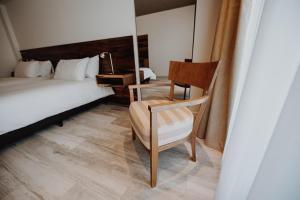 里奥夸尔托La Urumpta Hotel by AKEN Mind的一间卧室配有一张床、一把椅子和一张书桌