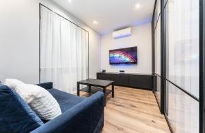 基辅Modern loft style apartment的客厅配有蓝色的沙发和电视