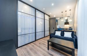 基辅Modern loft style apartment的客厅设有蓝色的沙发和大窗户