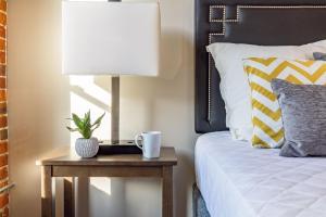 斯波坎Riverfront Park Travel Apartments的一间卧室配有一张桌子、一盏灯和一张床