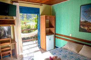 穆库热Pousada Recanto da Chapada的一间卧室设有一张床、一个窗口和一台电视