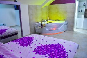 帕拉钦Apartmani Tajna的一间带浴缸和紫色花床的卧室