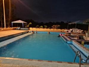 Cabuyal马德普拉塔旅馆的和水中的人一起在晚上使用游泳池