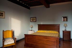 切雷托圭迪Agriturismo La Colombaia的一间卧室配有一张木床和一把椅子