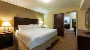 坎卢普斯假日套房酒店-坎卢普斯的一间酒店客房,设有一张大床和一个走廊
