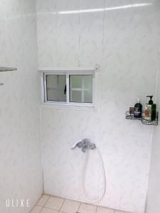 南庄乡星原谷露营区的白色浴室设有淋浴和窗户