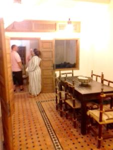 拉巴特3 bedrooms house at Rabat 800 m away from the beach with furnished terrace的两个人站在一个桌子的房间