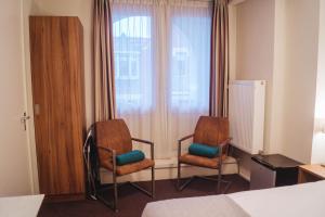 厄伊特赫伊曾埃克哈特酒店的酒店客房设有两把椅子和一扇窗户。
