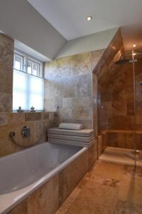 博尔格苏姆Friesenliebe的大型浴室设有浴缸和淋浴。