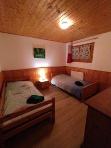 普雷芒翁达里亚公寓的一间卧室设有两张床和木制天花板