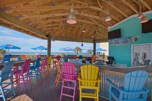巴拿马城海滩Ramada by Wyndham Panama City Beach / Beachfront的一间设有五颜六色椅子的餐厅和一间酒吧