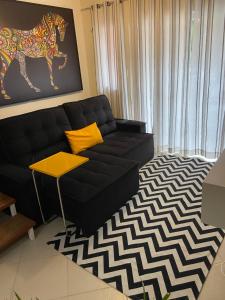 佩尼多Vila Noel Premium的客厅配有黑色沙发和黄色枕头