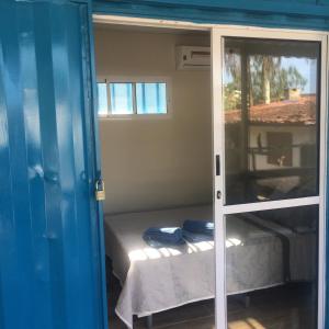 乌巴图巴Farol da Barra Seca Ubatuba的配有床和滑动玻璃门的房间