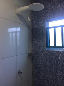 乌巴图巴Farol da Barra Seca Ubatuba的浴室设有玻璃门和窗户,配有淋浴