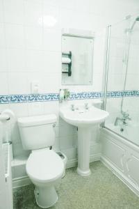 沃里克老式四便士旅馆的白色的浴室设有卫生间和水槽。