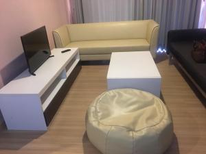 华欣Bluroc Hua Hin Apartment的客厅配有沙发、桌子和椅子