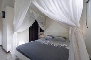 莱特鲁瓦西莱Eden plage的卧室配有带白色窗帘的天蓬床