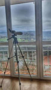 大特尔诺沃Tsarevets panoramic apartments Veliko Tarnovo的窗前三脚架上的相机