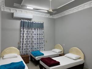 阿尔哈姆拉Dar ALHamra Inn的客房设有两张床和吊扇。