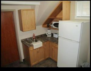 萨斯卡通BUDGET LODGE的厨房配有白色冰箱和水槽
