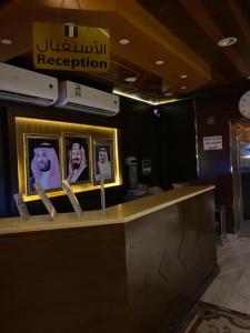 延布Al Fanar Al Alamaya 3- Hay'aa Malakeya entrance的餐厅里一张桌子,上面有人们的照片