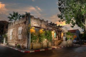 特拉维夫Trieste Neve Tzedek Boutique Suites Tel Aviv的一座种植了植物的古老石头建筑