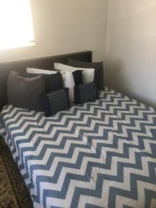 诺福克Cozy Mother-in-Law Suite的一张带蓝色和白色床单及枕头的床
