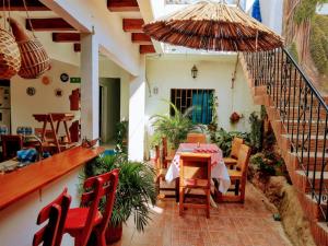 里奥阿查Hostal Solsticio Guajiro的庭院配有桌椅和遮阳伞。