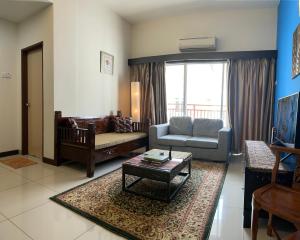 马六甲Homestay 3 rooms suite Apartment 8-10pax at Amari Villa Bukit Katil, Ayer Keroh Melaka的客厅配有沙发和桌子