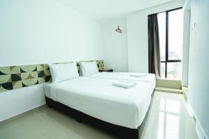 巴特沃思Grand Bagan Hotel的卧室配有一张大白色床和窗户