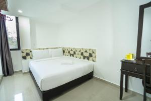 巴特沃思Grand Bagan Hotel的卧室配有白色的床和床头柜