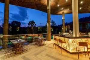 蔻立Kalima Resort and Villas Khao Lak - SHA EXTRA PLUS的一个带桌椅的庭院和一间酒吧