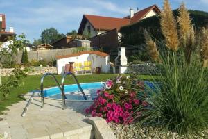 KatsdorfVilla Casa sol-rural residence near Linz的一座游泳池,位于一个拥有粉红色花卉的庭院内