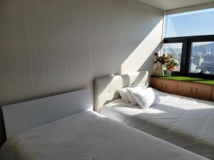 首尔Samseong Coexmall AA的一间卧室设有两张白色的床和窗户