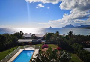 圣吕斯La Perle piscine et plage petite VUE MER的享有度假胜地的空中景致,设有游泳池和海洋