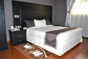 莫希Panone Hotels - King'ori Kilimanjaro Airport的一间卧室配有一张大床和黑色床头板