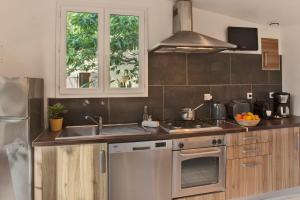 卡尔维minivilla lilas indépendante à Calvi avec jardin et piscine jardin et bbq的厨房配有水槽和炉灶 顶部烤箱