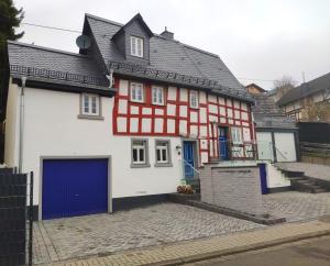 HübingenHübingen Cottage的一间红色和白色的房子,设有蓝色车库