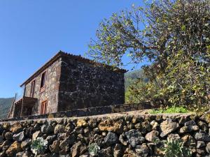 TigalateCasa Rural Quinta Los Naranjos的石墙顶上的古老石头建筑