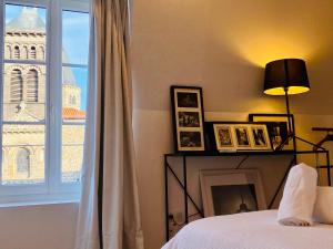 克莱蒙费朗Charmant T2 Cosy Notre Dame du Port的一间卧室配有一张床,窗户带有塔楼