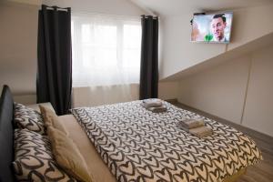 诺维萨德Central Sweet Home I.M.的卧室配有一张床,墙上配有电视。