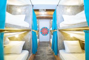 帕洛米诺Freesoul Hostel的一间设有四张双层床和蓝色窗帘的房间
